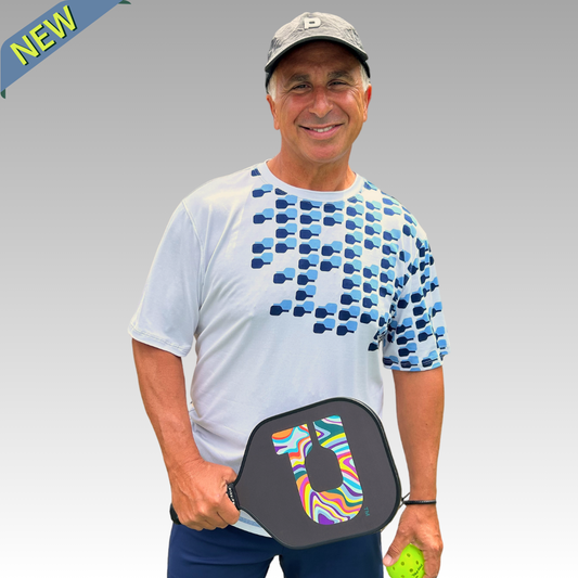 Man holding a pickleball paddle with a colorful design on a gray background