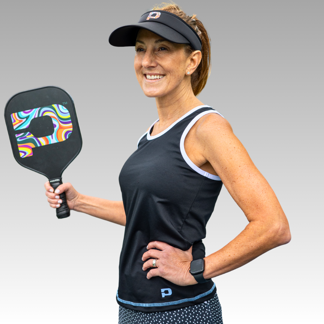 Woman holding a pickleball paddle with Black tank