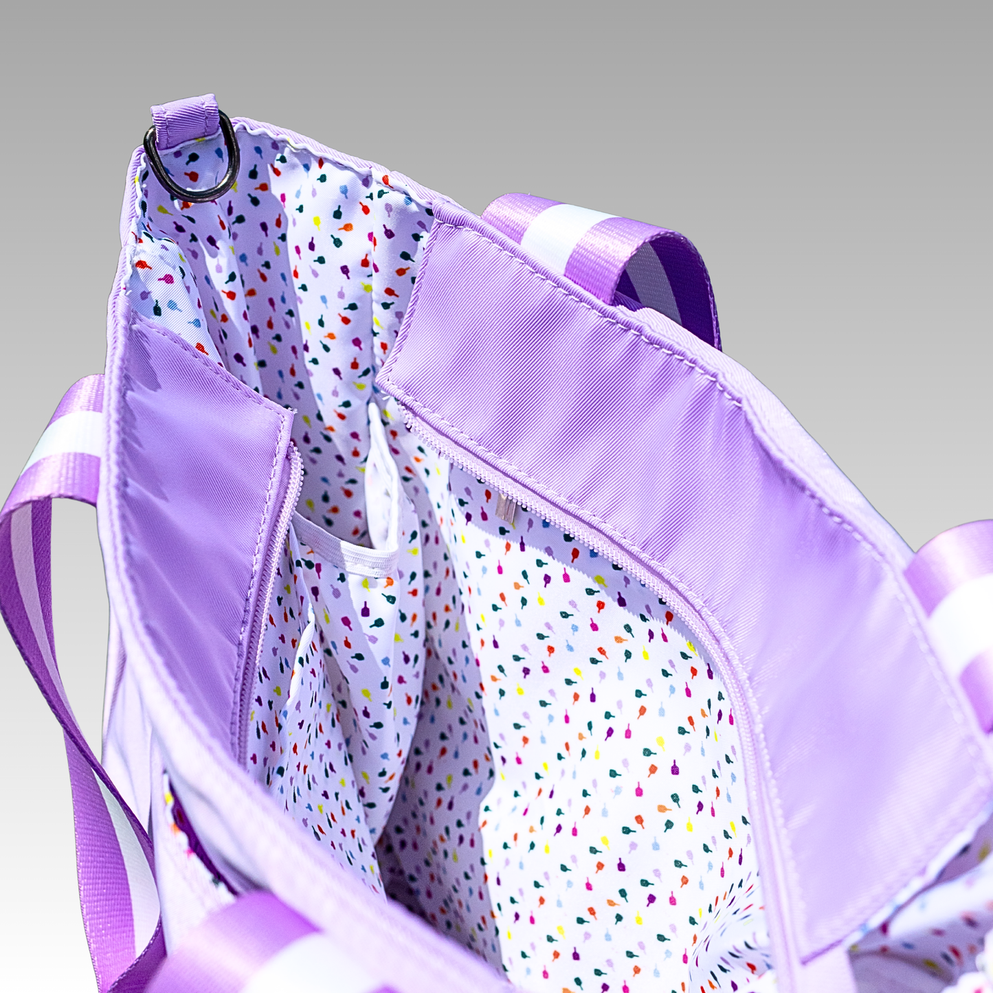 Purple bag with colorful polka dot interior on a gray background