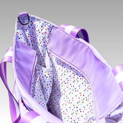 Purple bag with colorful polka dot interior on a gray background