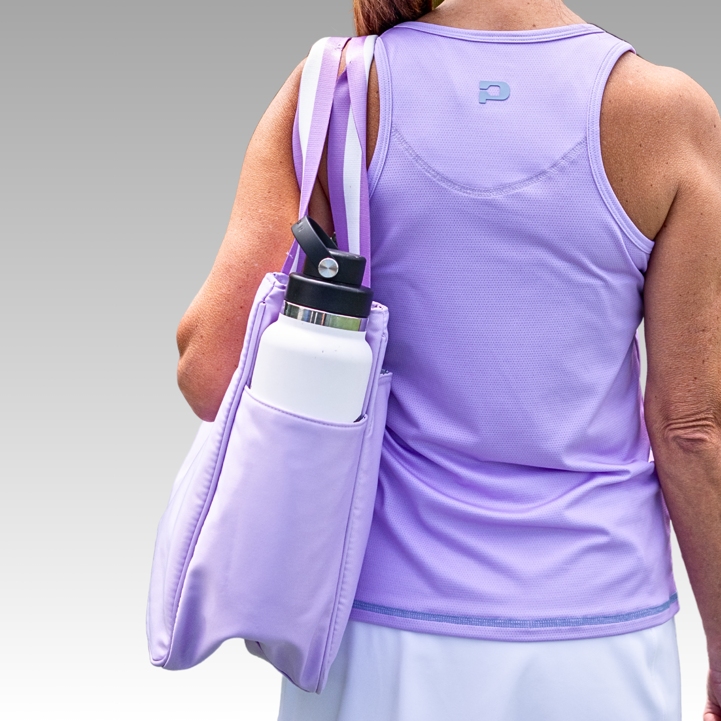 Person wearing a purple tank top with a matching bag and water bottle.