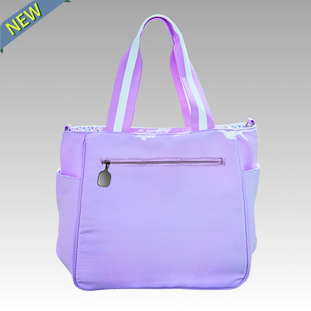 Purple pickleball tote bag with a visible brand logo and a pickleball shaped zipper on a gray background