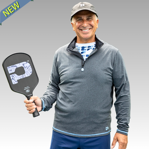 Man holding a pickleball paddle with a gray background