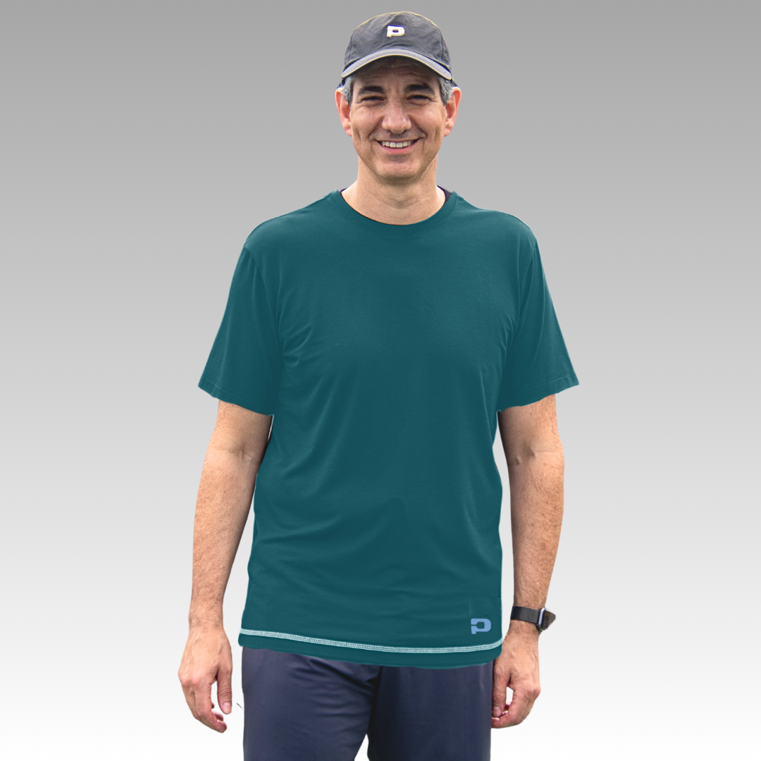 Man wearing a teal t-shirt and navy cap on a gray background