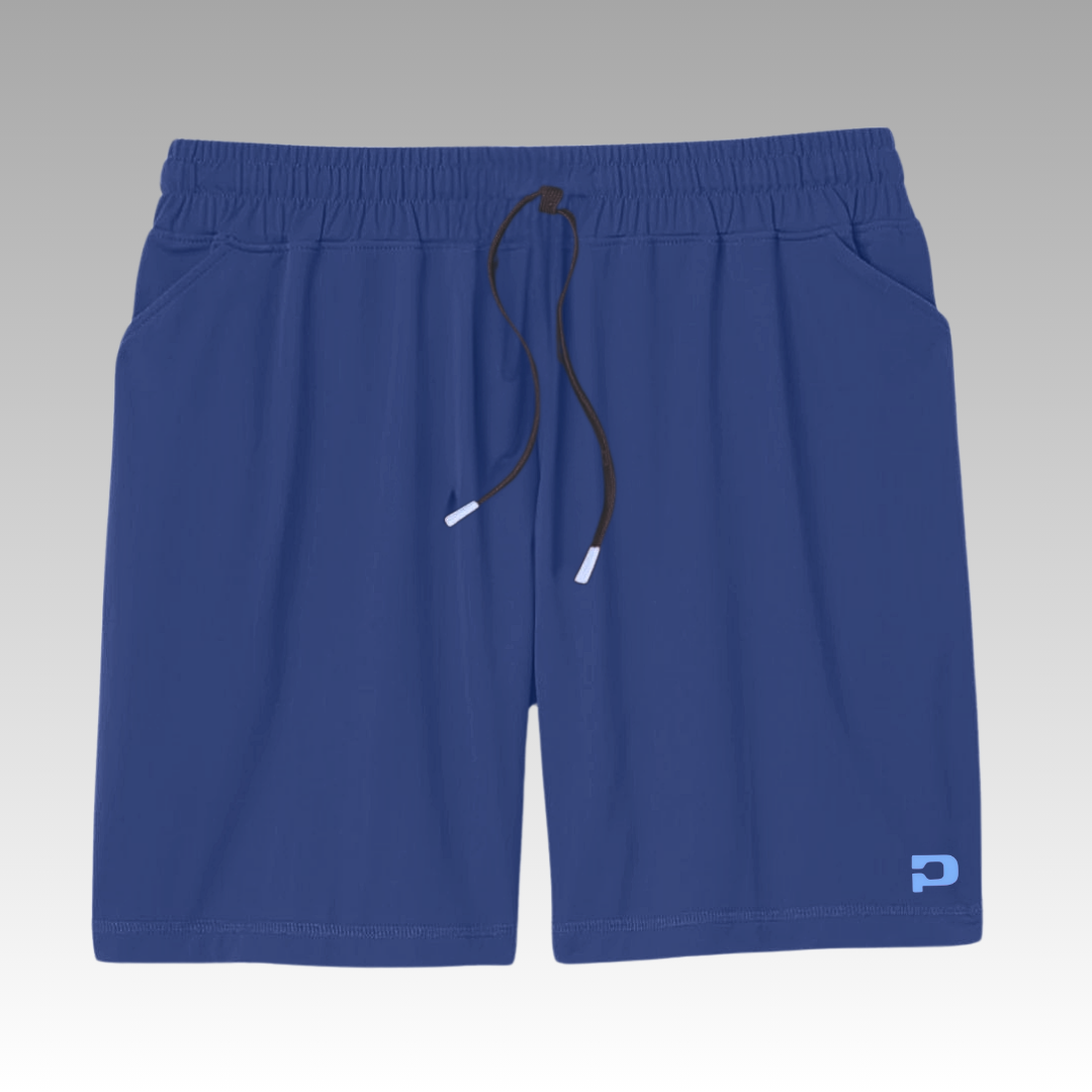 Person wearing blue shorts with a paddle and ball, on a gray background