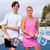 Two young people posing in gear by pickleball net